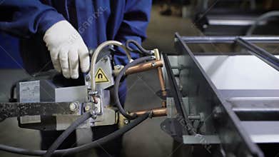 Work using mechanized hand for spot welding of metal izdeliy.Muzhchina working in a factory with a metal, its duty spot