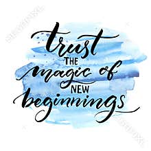 Trust the magic of new beginnings. Inspiration saying. Vector brush calligraphy on blue watercolor strokes. Encouraging