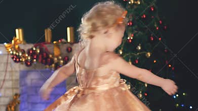 Cute little girl dancing, background decorated Christmas tree