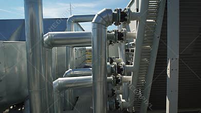 Metal chrome pipes are connected to a common water supply system for the enterprise. On the roof of an industrial