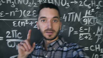 Young scientist man making selfie shoot in chemical and mathematical equations wall room interior