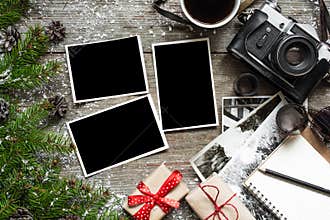 Vintage photo camera on christmas wooden background with blank photo frame