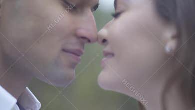 Closeup of a young couple kiss Male and female rub their noses and kiss Guy with girlfriend spending time together