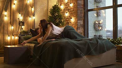 Jealous woman spying on phone of sleepy man in bed