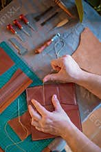 Craft man is working on his leather craft, making vintage leather bag by leather work tool.