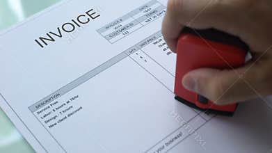 Invoice past due, worker hand stamping seal on commercial document, business