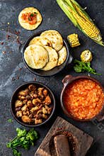 COLOMBIAN traditional food. Chicharron, maize arepas with tomato and onion sauce. Top view