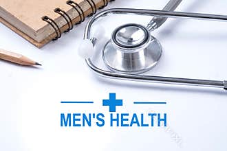 Stethoscope, notebook and pencil with men`s health words. Health