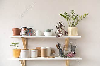 Utensils and mugs on shelf