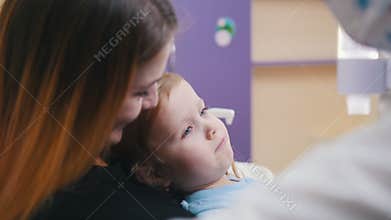 Medicine, dentistry. Female dentist examines the oral cavity of little baby
