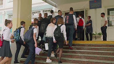 MOSCOW - SEPTEMBER 1, 2018: Teenaged children in uniform with backpacks and bags near school on first of september