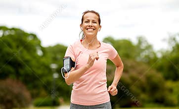Woman with earphones add armband jogging at park
