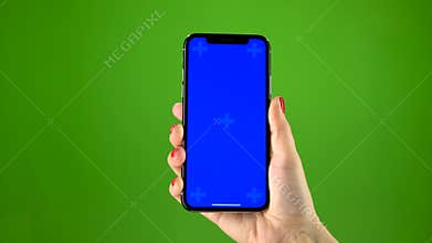 Female hand holding the newest smartphone on green screen