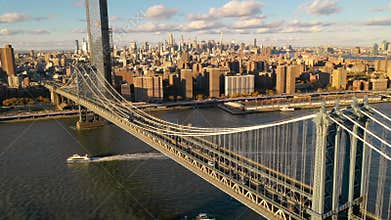 The Manhattan Bridge Crosses the East River in New York City as cruise boats move below