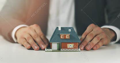 Real estate agent showing model of the new house