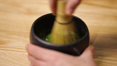 Mixing matcha tea in bowl