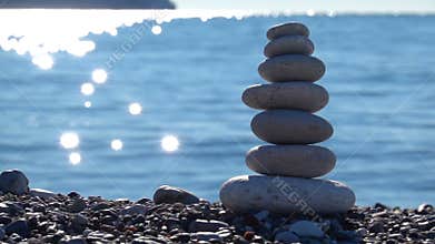 Zen stones on beach for perfect meditation. Calm zen meditate background with rock pyramid on sand beach symbolizing