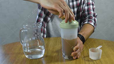Man makes a protein cocktail after a workout, hands close-up.
