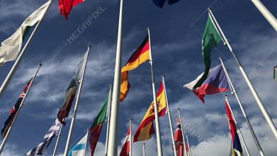 Flags of many countries waving in the wind on the blue sky and white clouds. Politics, relationship, international meeting, trade,