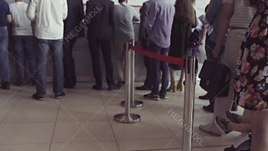 Queue of people waiting in line to be served. The queue of people standing in the cash. Could be a post office, bank or