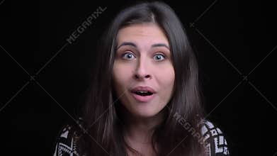 Closeup shoot of young beautiful caucasian female getting surprised and excited in front of the camera with background