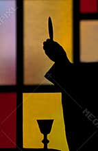 Silhouette of priest lifting host