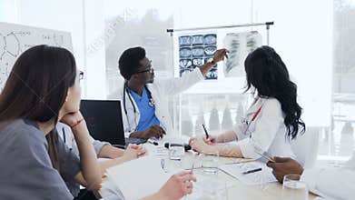 Group of multi-ethnic of professional doctors discussing x-ray prints of patient in the clinic. Health, hospital