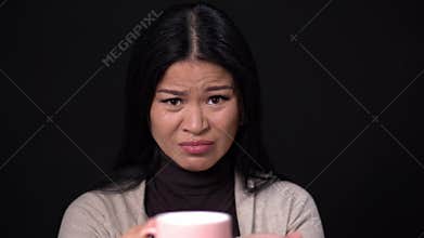 Lovely Asian dislikes the taste of the coffee