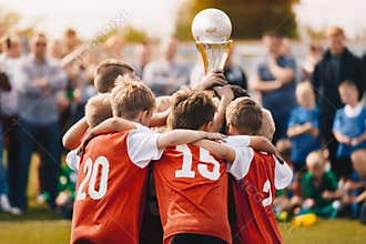 Young Athletes from School Sports Team Holding Winning Trophy. Kids Champion Sport Team. Boys Holding Prize Cup