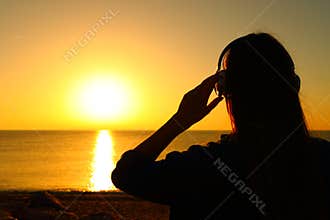 Woman listening chill out music at sunset
