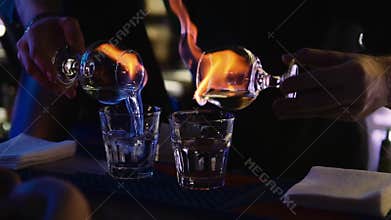 Barman sets fire to a burning cocktail at the bar