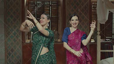 Pretty females in sari dancing in indian manner