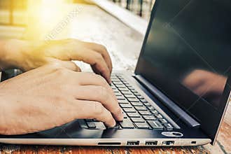 Side view shot of working at cafe with laptop man writing a blog. male hands on the keyboard