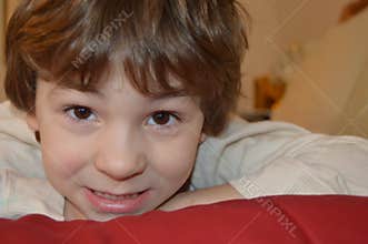 Little Boy Resting Head on Red Blanket