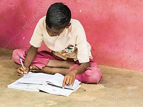 Group of serious children friends boys classmates studying with book sitting on floor outdoor at the school playground. School