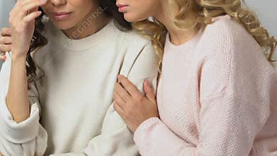 Caring woman calming and supporting her upset best friend, bad news, break-up