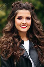 Beautiful woman with long curly hair in leather jacket.