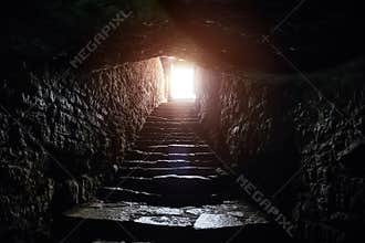 Underground passage under old medieval fortress. Old stone stairs to exit of tunnel