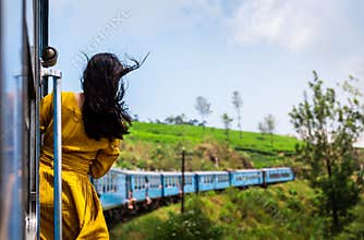 Woman enjoying train ride through Sri Lanka tea plantations