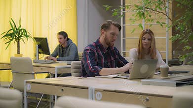 Woman and man discussing business processes, open space office.