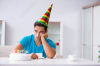 The young man celebrating birthday alone at home