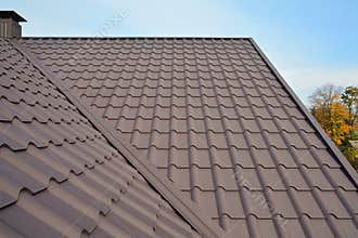 Metal Roof Construction Against Blue Sky. Roofing materials. Metal House roof. Closeup House Construction Building Materials.