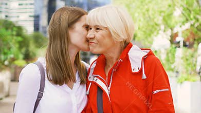 Senior mother and her young daughter standing on street. Happy family enjoying time together