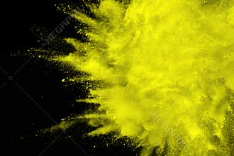 Abstract yellow dust explosion on black background.