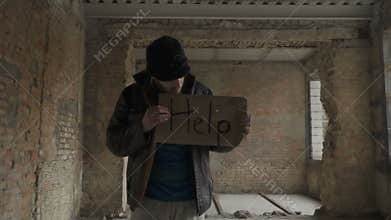 Portrait of sick dirty homeless with table `help`
