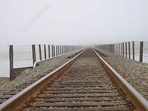 Railroad tracks into fog