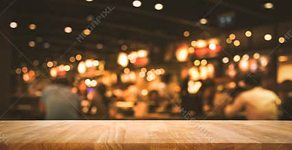 Wood table top Bar with blur light bokeh in dark night cafe
