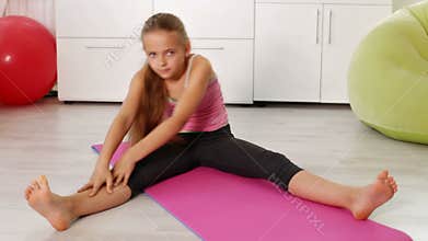 Young girl exercising at home - stretching
