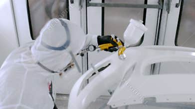 A professional car painter is painting a body work