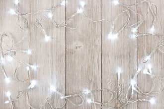 White Christmas lights frame over light gray wood